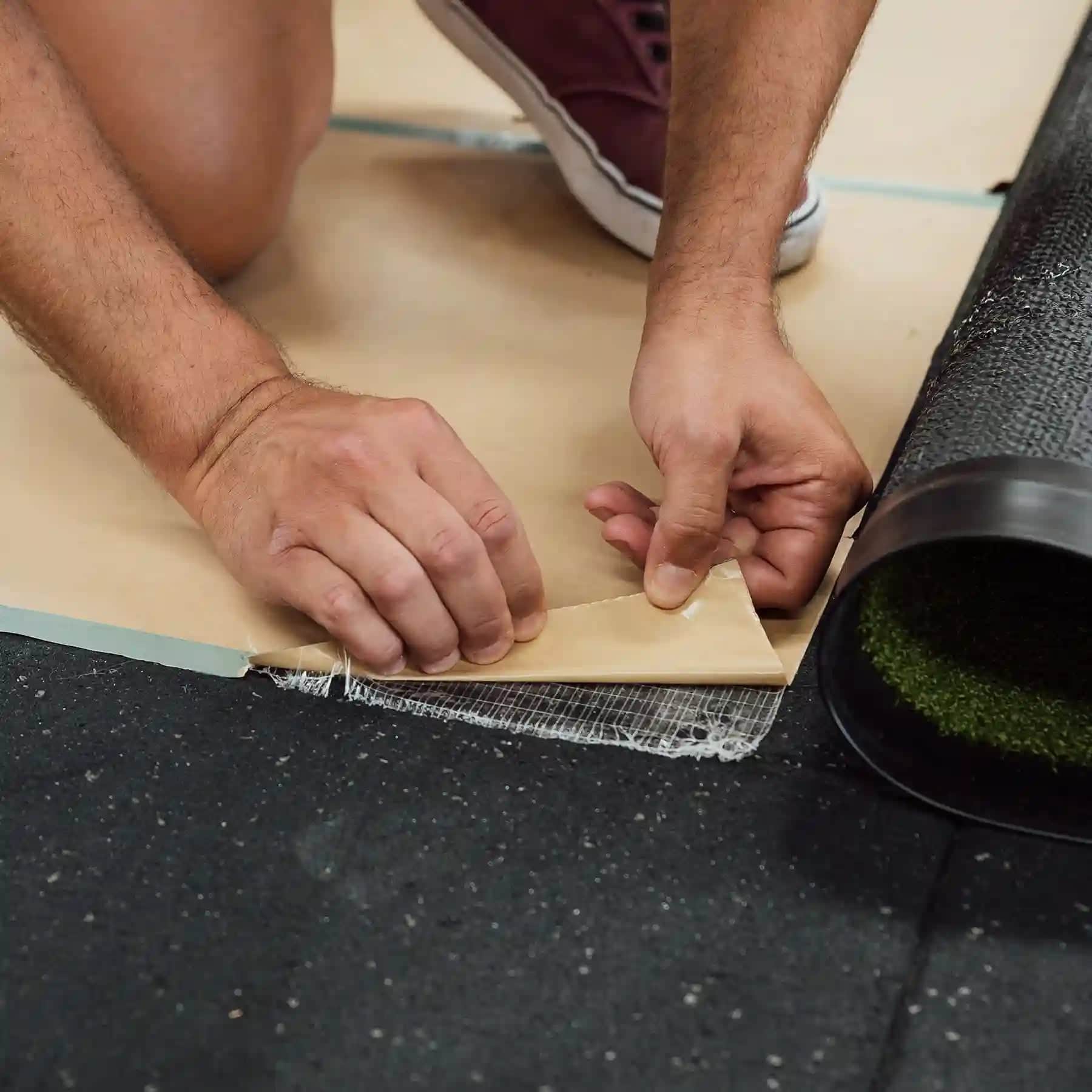 Applying Endurance double-sided installation tape to a Heroturfs track